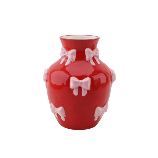 Vaso vermelho alto com laços rosa decorativos.