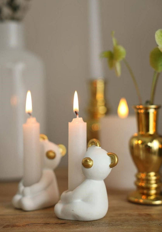 Suporte de vela branco em forma de urso com detalhes dourados.