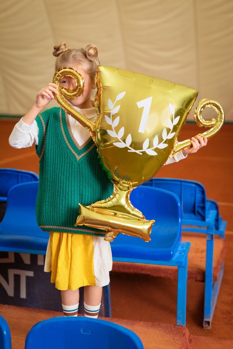 Criança com balão de taça dourada